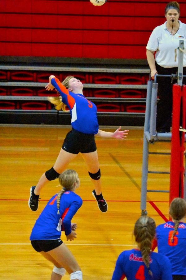 Maci Wolf spikes the ball during a volleyball match.