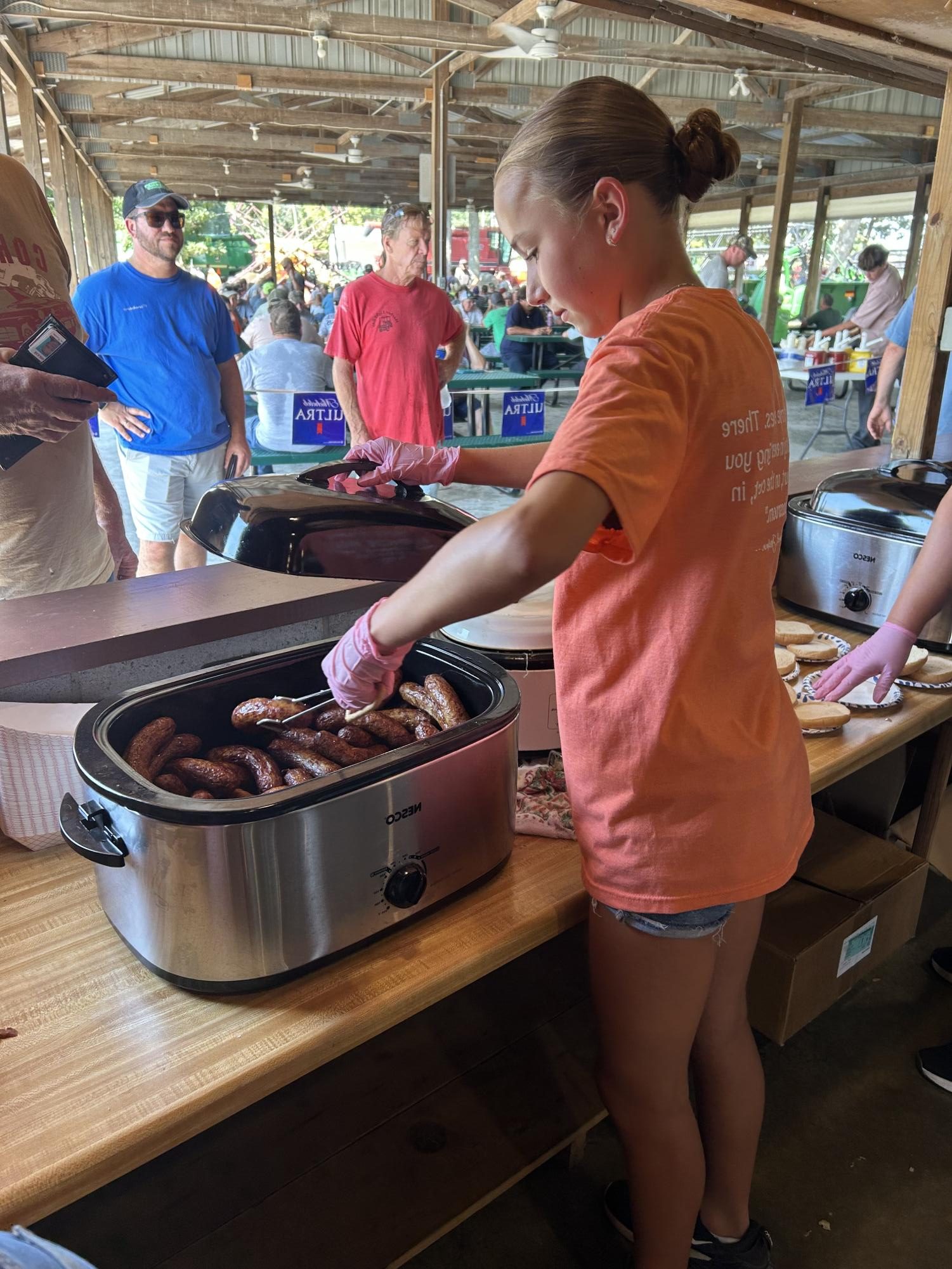 Freshman, Brooklyn Meier, serves a farmer at the auction.